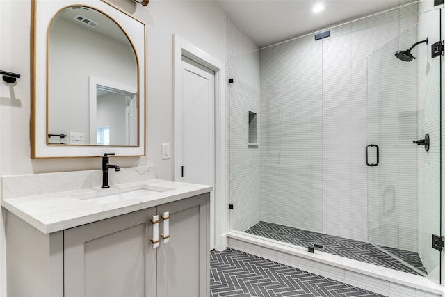 bathroom with walk in shower, vanity, and tile patterned flooring