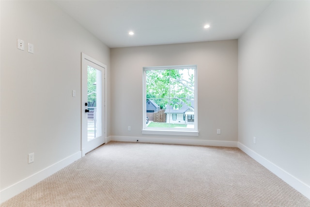 carpeted spare room featuring a healthy amount of sunlight