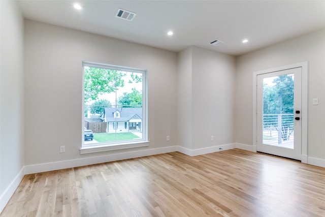 unfurnished room featuring a wealth of natural light and light wood-type flooring