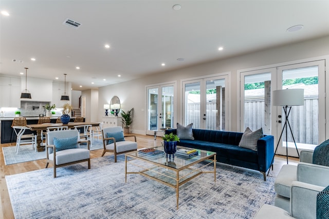 living room with light hardwood / wood-style flooring and french doors