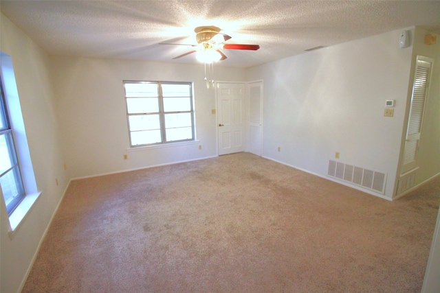 carpeted empty room featuring a textured ceiling and ceiling fan