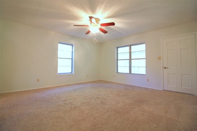 spare room with a textured ceiling, carpet floors, and ceiling fan