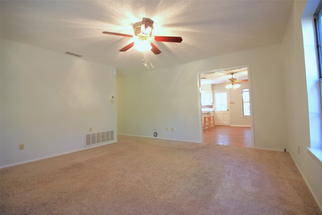 spare room with ceiling fan, a textured ceiling, and carpet floors