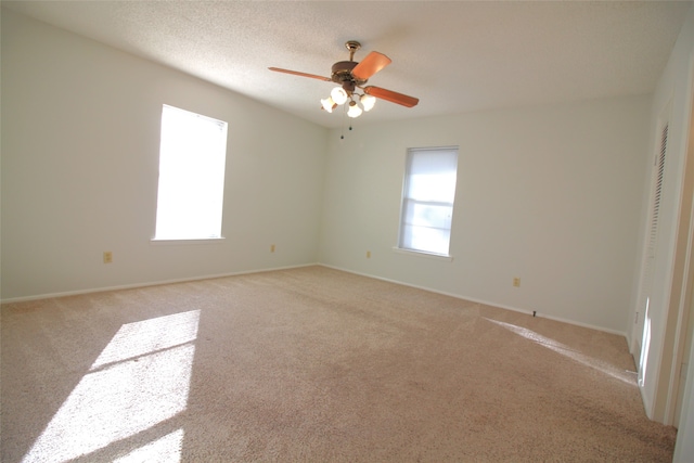 carpeted empty room featuring a textured ceiling and ceiling fan