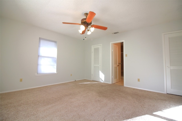 empty room with light colored carpet and ceiling fan