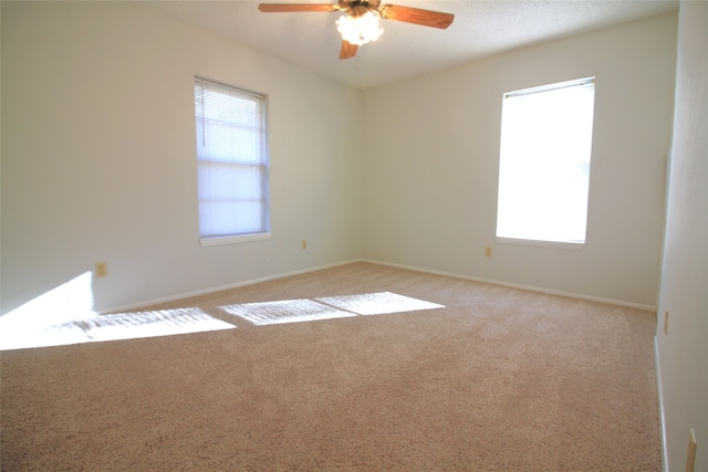 spare room with ceiling fan and light colored carpet