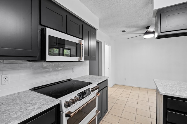 kitchen featuring tasteful backsplash, light tile patterned flooring, stainless steel appliances, a textured ceiling, and ceiling fan