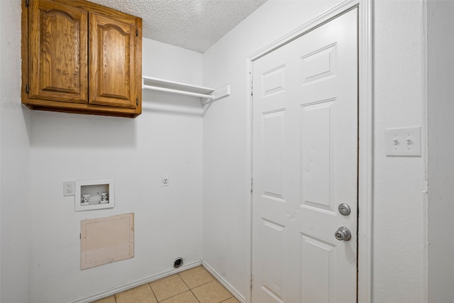 laundry room with washer hookup, cabinets, a textured ceiling, and light tile patterned floors