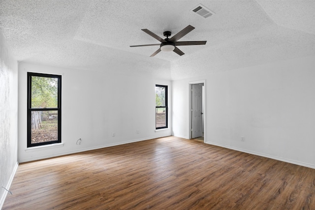 unfurnished room with a textured ceiling, hardwood / wood-style floors, and a healthy amount of sunlight