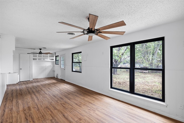 spare room with a textured ceiling, hardwood / wood-style flooring, and ceiling fan