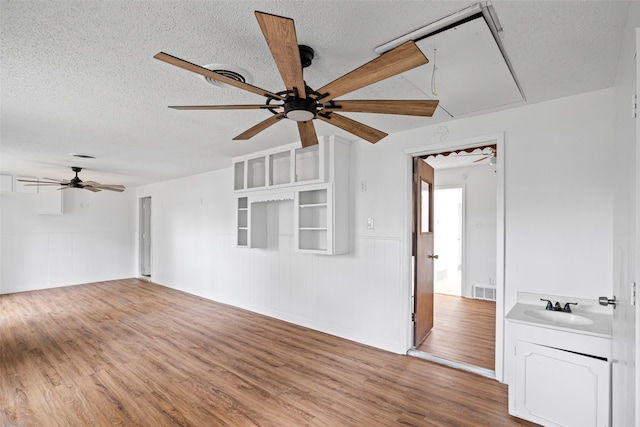 spare room with sink, a textured ceiling, and hardwood / wood-style flooring