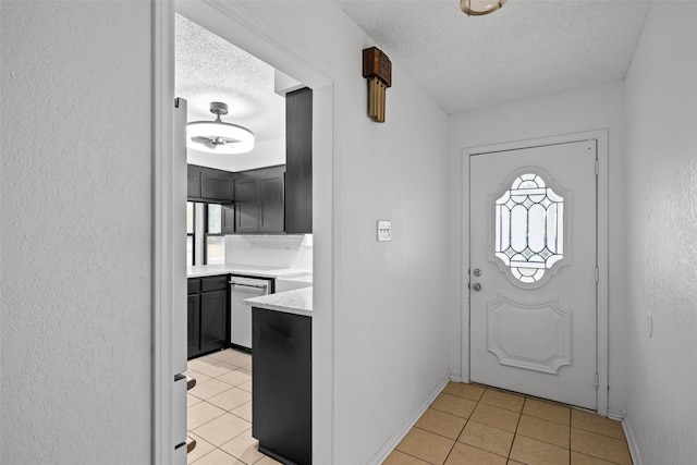 tiled foyer featuring a healthy amount of sunlight and a textured ceiling