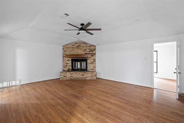 unfurnished living room featuring a fireplace, hardwood / wood-style flooring, ceiling fan, and vaulted ceiling