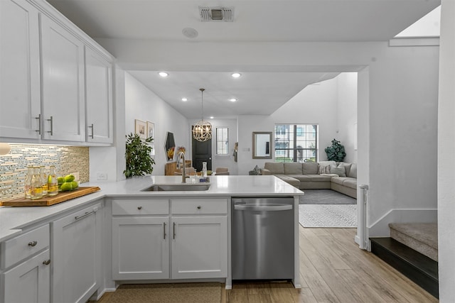 kitchen featuring dishwasher, kitchen peninsula, white cabinets, sink, and light hardwood / wood-style flooring