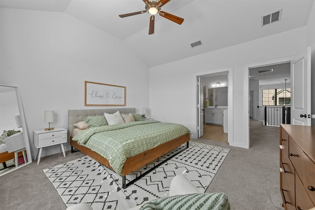 carpeted bedroom with vaulted ceiling, ceiling fan, and ensuite bath