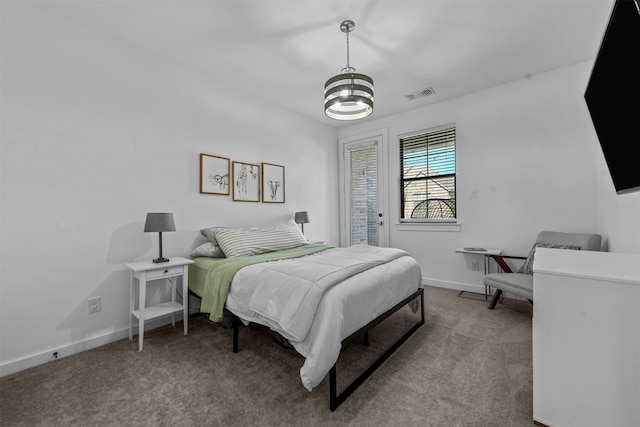 carpeted bedroom featuring a notable chandelier