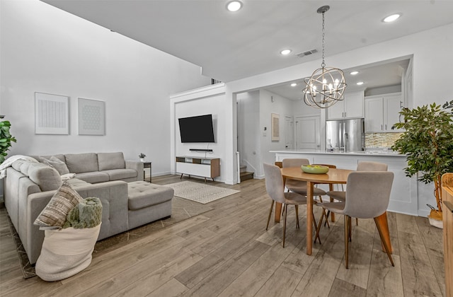 dining space with light wood-type flooring and a chandelier