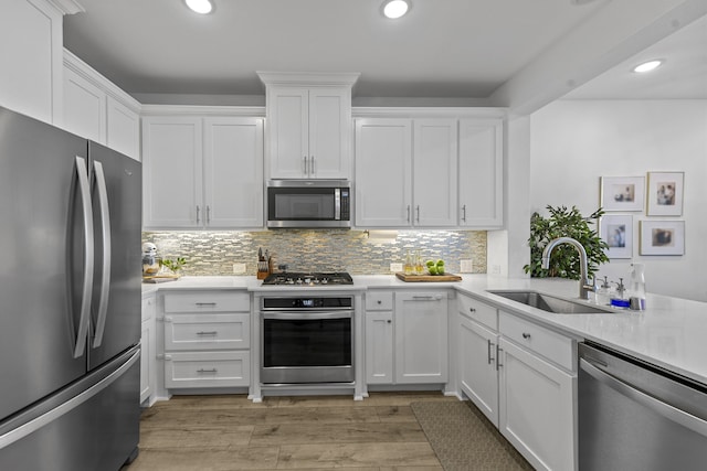 kitchen with stainless steel appliances, white cabinetry, and sink