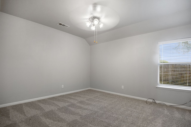 empty room featuring ceiling fan, lofted ceiling, and carpet