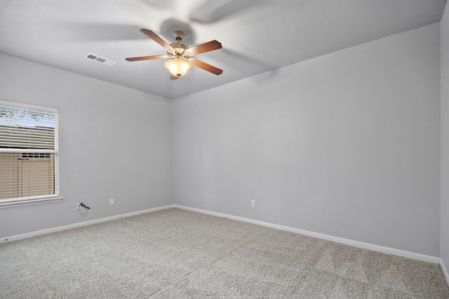 empty room featuring ceiling fan and carpet