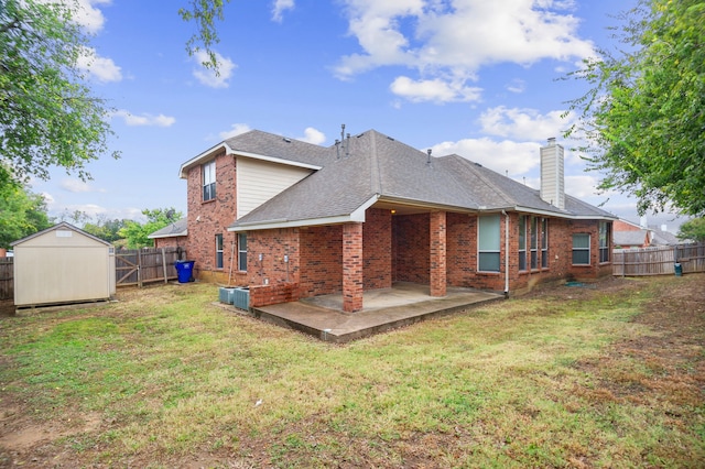 back of property featuring a storage shed, a patio, and a yard