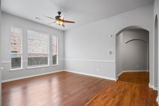 empty room featuring dark wood-type flooring and ceiling fan