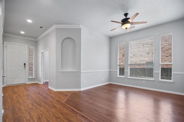 empty room with ceiling fan, crown molding, and dark hardwood / wood-style flooring