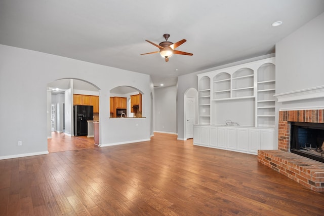 unfurnished living room with a fireplace, hardwood / wood-style flooring, and ceiling fan