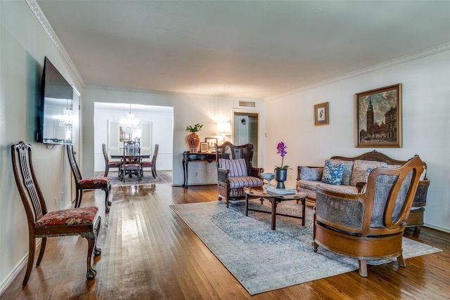 living room featuring an inviting chandelier, hardwood / wood-style flooring, and crown molding