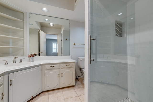 bathroom with toilet, vanity, tile patterned floors, and tiled shower