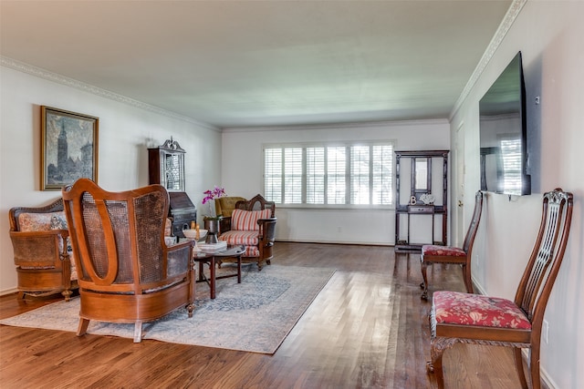 sitting room with hardwood / wood-style floors and ornamental molding