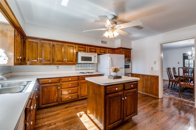 kitchen with sink, ceiling fan, white appliances, a kitchen island, and dark hardwood / wood-style flooring