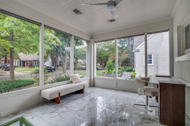 unfurnished sunroom featuring ceiling fan