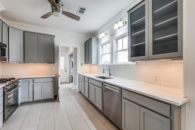 kitchen featuring stainless steel appliances, visible vents, a sink, and gray cabinetry