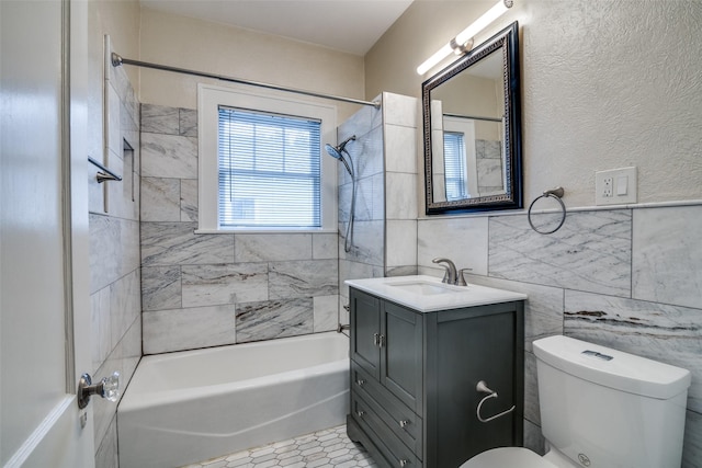 full bathroom with bathtub / shower combination, tile walls, toilet, and vanity