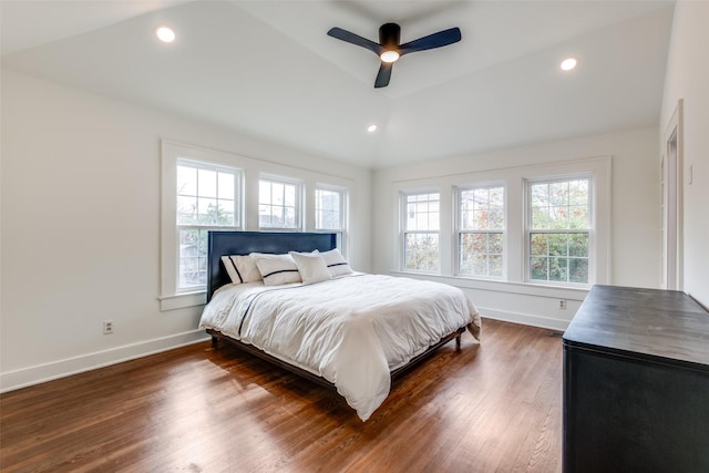 bedroom with lofted ceiling, dark wood-style flooring, multiple windows, and baseboards