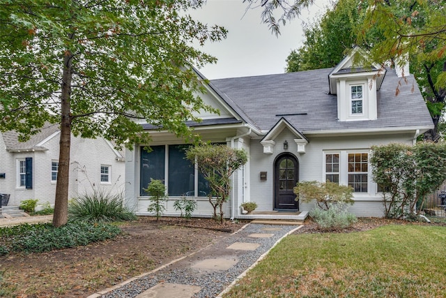 view of front of home with a front yard and brick siding