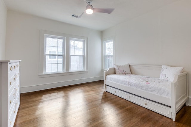 sitting room with baseboards, wood finished floors, visible vents, and a ceiling fan