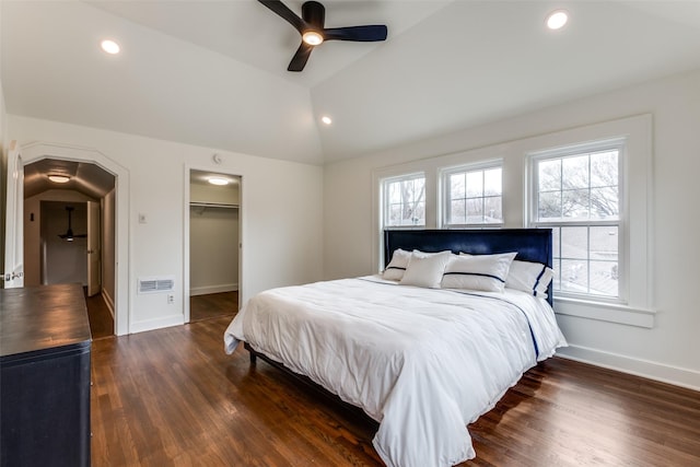 bedroom with wood finished floors, visible vents, vaulted ceiling, and multiple windows