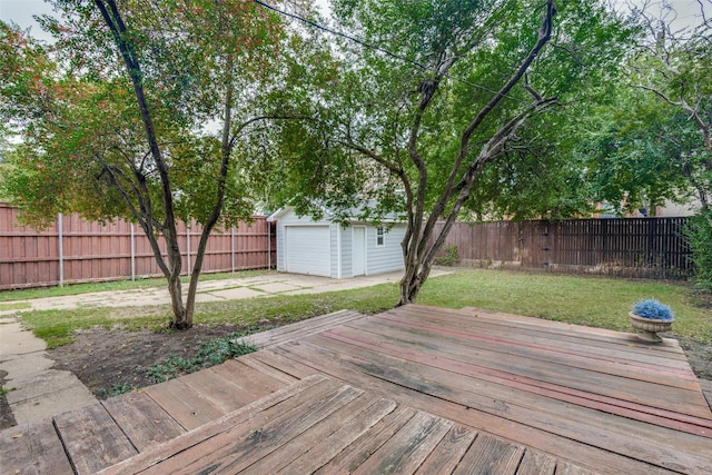 wooden terrace with a yard, a detached garage, a fenced backyard, an outdoor structure, and driveway