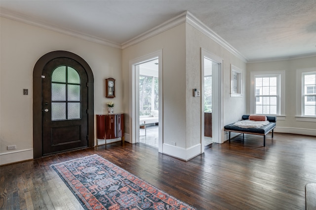 foyer entrance with dark wood-type flooring and crown molding