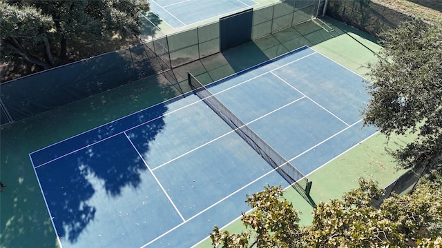 view of tennis court featuring fence