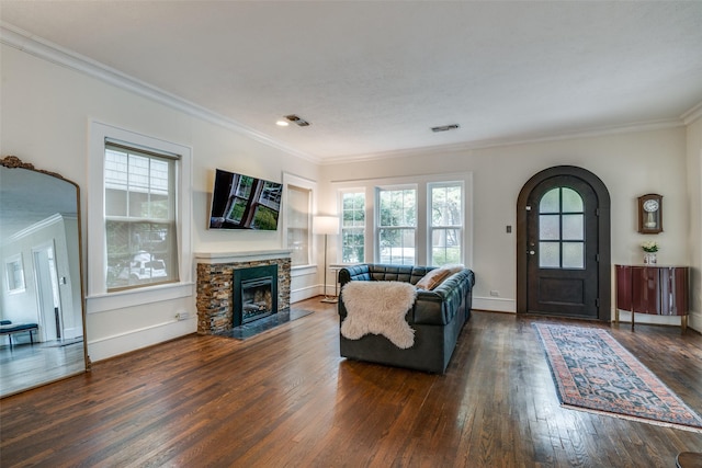 living room with arched walkways, dark wood-style flooring, a fireplace, visible vents, and ornamental molding