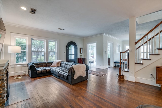 living area featuring a wealth of natural light, hardwood / wood-style floors, stairway, and visible vents