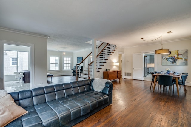 living area featuring stairs, ornamental molding, wood finished floors, and visible vents