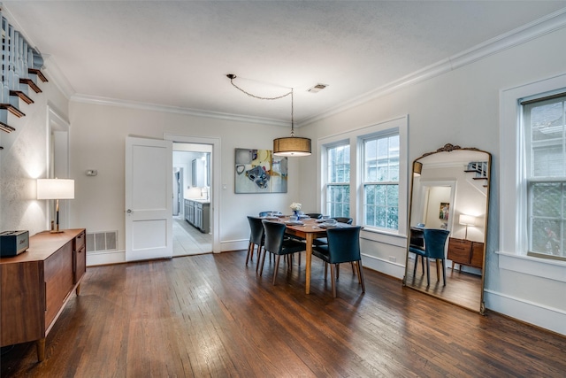 dining room with ornamental molding, dark wood finished floors, visible vents, and baseboards