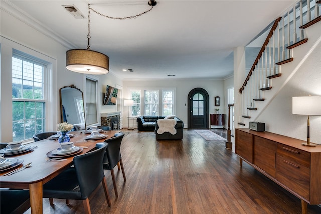 dining area with stairway, visible vents, dark wood finished floors, and crown molding