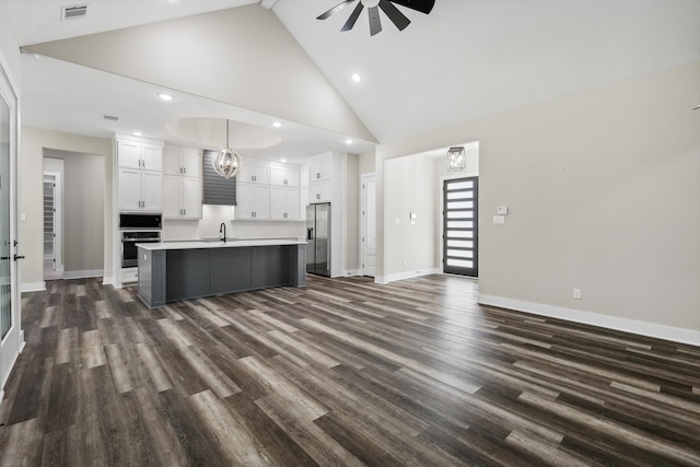 living room with dark hardwood / wood-style flooring, high vaulted ceiling, sink, and ceiling fan with notable chandelier