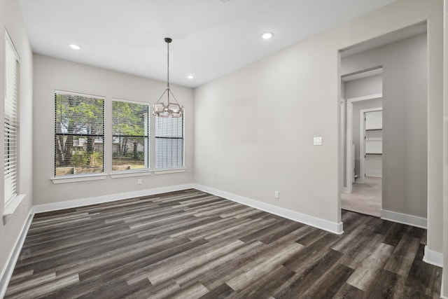 unfurnished dining area featuring dark hardwood / wood-style floors and a notable chandelier