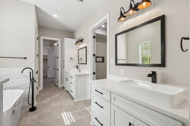 bathroom featuring tile patterned flooring, vanity, a bathing tub, and tile walls